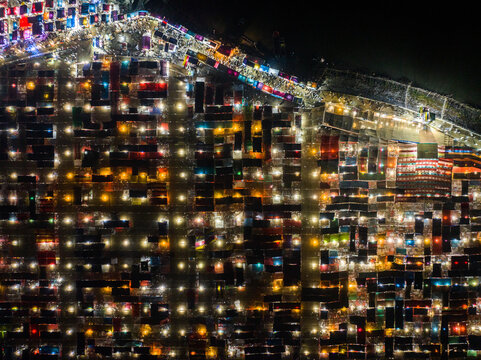 Aerial view of the illuminated Charmonai Mahfil gathering, with a vast grid of tents and stalls creating a vibrant pattern of lights at night in Charmonai, Barisal Division, Bangladesh.