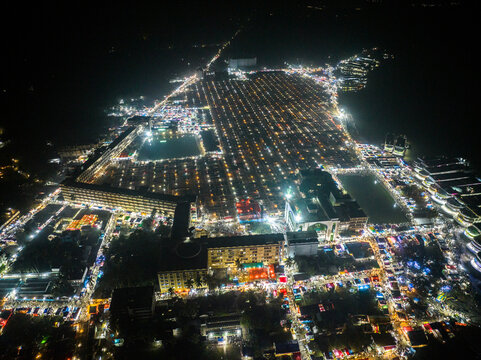 Aerial view of the illuminated Charmonai Mahfil gathering at night with rows of tents and crowds in Charmonai, Barisal Division, Bangladesh.