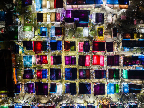 Aerial view of the vibrant night market in Charmonai, featuring rows of colorful illuminated tents arranged in a grid pattern, bustling with activity in Charmonai, Barisal Division, Bangladesh.