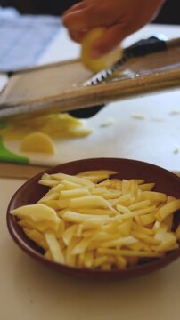 Slicing raw potatoes with mandoline slicer in kitchen video