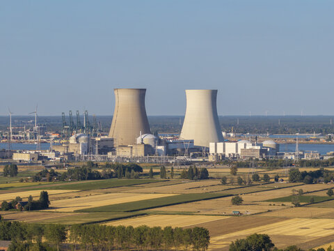 Aerial view of the Doel Nuclear Power Plant with cooling towers, surrounded by agricultural fields and the Scheldt river in Beveren-Kruibeke-Zwijndrecht, Vlaanderen, Belgium.