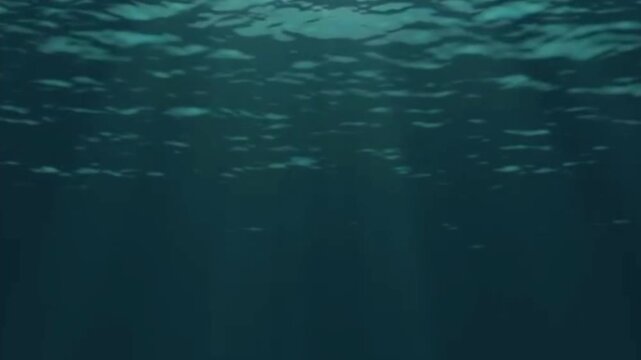 Beautiful sunlight streams down through clear deep blue ocean water creating a magical shimmering effect below the surface