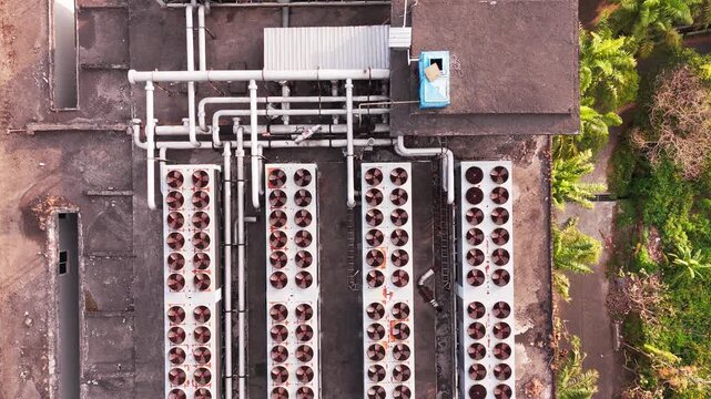 Aerial view of data center rooftop equipped with heavy-duty cooling units, industrial ventilation fans, condenser systems, and pipes for temperature control. Ideal for commercial technology, industria