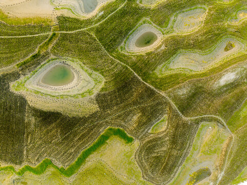 Aerial view of agricultural fields with small ponds and intricate soil patterns in Rajshahi, Rajshahi Division, Bangladesh.