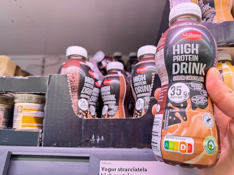 Mallorca, spain, august 30, 2026, hand holding chocolate high protein drink bottle with nutri score in supermarket, focusing on healthy lifestyle products