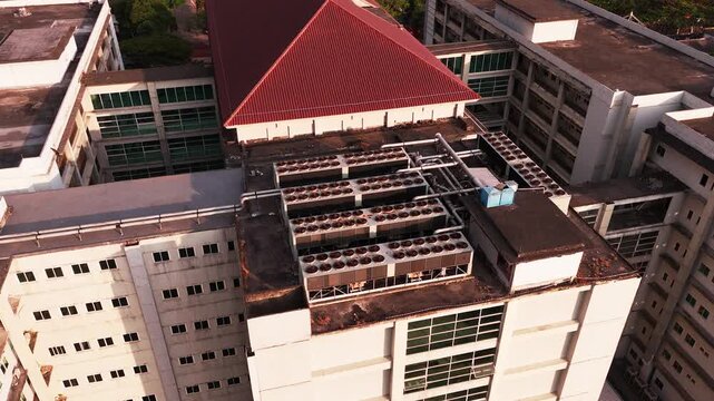 Aerial view of data center rooftop equipped with heavy-duty cooling units, industrial ventilation fans, condenser systems, and pipes for temperature control. Ideal for commercial technology, industria
