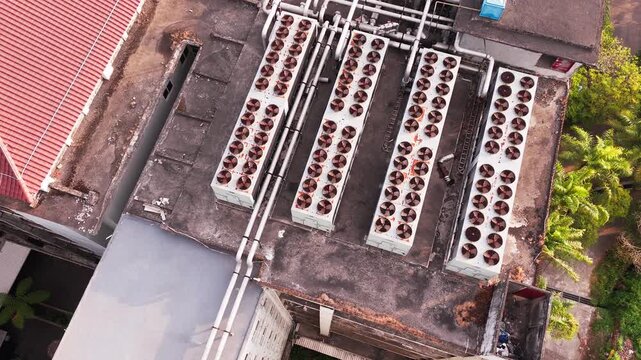 Aerial view of data center rooftop equipped with heavy-duty cooling units, industrial ventilation fans, condenser systems, and pipes for temperature control. Ideal for commercial technology, industria