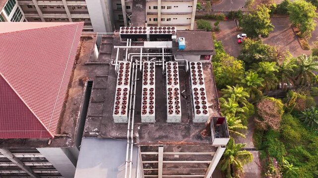 Aerial view of data center rooftop equipped with heavy-duty cooling units, industrial ventilation fans, condenser systems, and pipes for temperature control. Ideal for commercial technology, industria