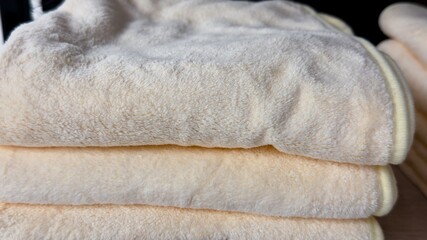 Clean Stack of Soft Light Yellow Plush Blankets for Cozy Home and Nursery Concept © Alla