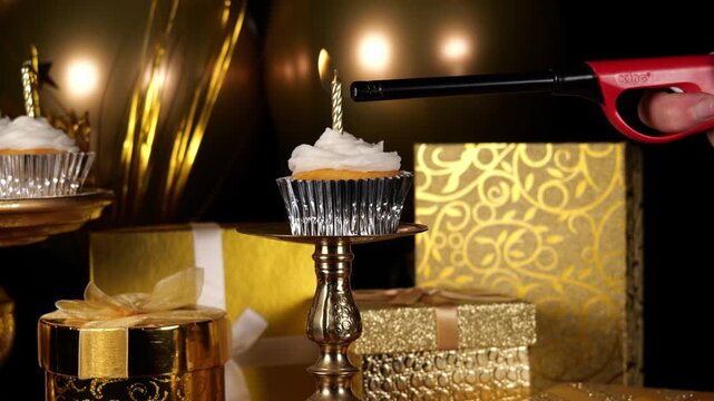 Lighting a Single Candle on a Cupcake with Gold Presents and Balloons in the Party Background