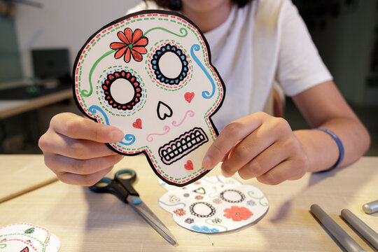 Person holding handmade paper calavera for Day of the Dead celebration