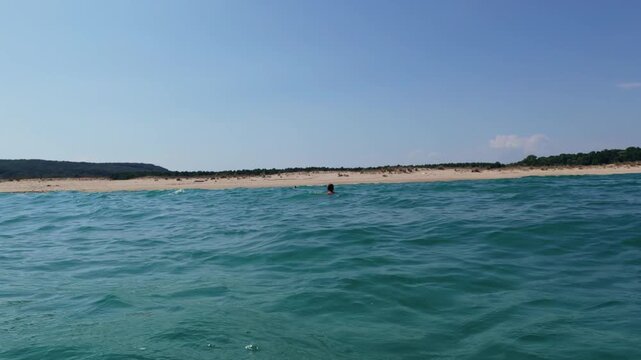 POV First Person View Hands Swimmer Floating in Blue Ocean Water near Beach