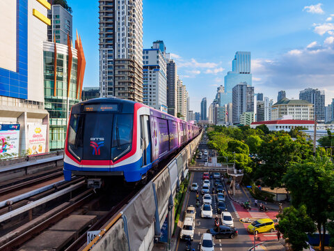Bangkok, Thailand - July 8, 2026 : The BTS Skytrain runs in and out of Victory Monument Station in the afternoon, showing the other side of the station.