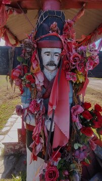 Gauchito Gil roadside shrine near route 93 in Firmat, Santa Fe, Argentina. Vertical, 9:16, mobile-ready.