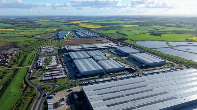 Elevated drone shot of large scale freight distribution hub and intermodal rail terminal at sunset in South Yorkshire