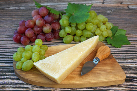 parmesan cheese and grapes on wooden