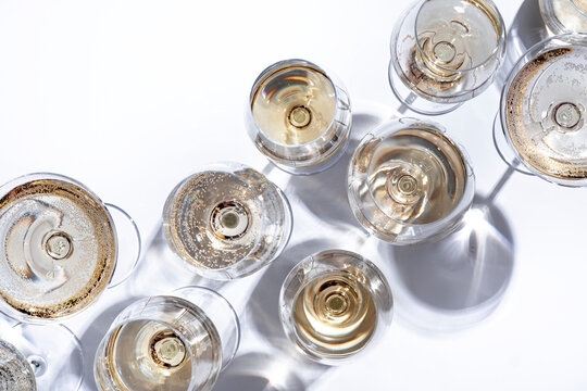 Elegant Chardonnay white wine in crystal glass &mdash; luxury sommelier tasting event. Chablis and Burgundy regional selection presentation. Premium aroma evaluation with hard sunlight shadows.