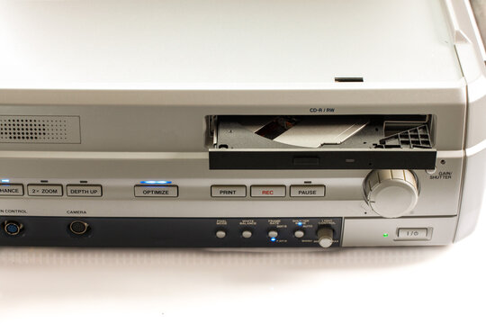 Vintage microscope imaging system with an open CD-R/RW drive, control buttons, recording controls, camera ports and light adjustment panel on a white background.