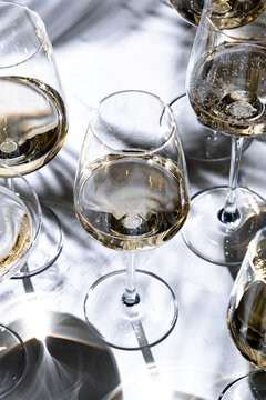 Clear Chardonnay white wine under bright sunlight &mdash; premium tasting catering event. Elegant crystal glasses with Burgundy regional selection. Luxury lifestyle concept featuring aroma.