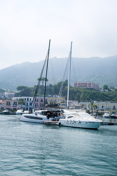 Ischia, Italy - August 7, 2026. Marina of Casamicciola Terme with Yachts and Mist-Covered Mountains in Ischia. A captivating wide-angle view of the bustling harbor at Casamicciola Terme on the norther