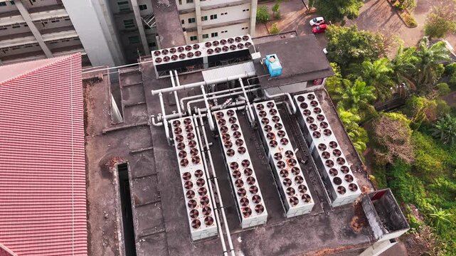 Aerial view of data center rooftop equipped with heavy-duty cooling units, industrial ventilation fans, condenser systems, and pipes for temperature control. Ideal for commercial technology, industria
