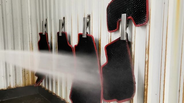 Process of washing rubber car mats using high pressure water jet at self service station. Clean car mats for interior hygiene. Professional automotive maintenance at outdoor jet wash garage.