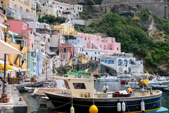 Procida, Italy - August 7, 2026. Traditional Fishing Boats and Colorful Cliffside Houses in Marina di Corricella, Procida. A stunning landscape view of the historic harbor at Marina di Corricella on t