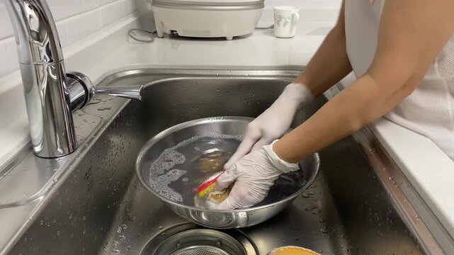 Cleaning a fresh abalone with a toothbrush in a kitchen sink
