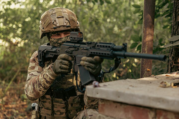 Obraz premium Armed military operator aiming a rifle during a combat patrol mission.