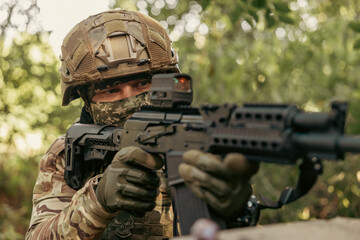 Obraz premium Armed military operator aiming a rifle during a combat patrol mission.