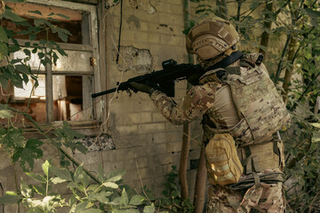 Obraz premium Armed military operator aiming a rifle during a combat patrol mission.