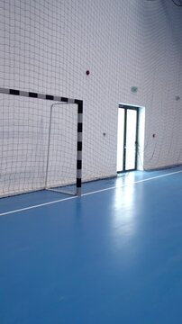 Empty indoor sports hall with blue flooring