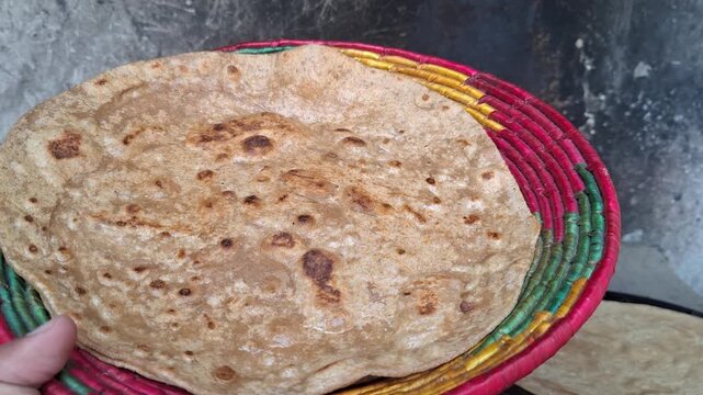 Freshly baked traditional Indian roti flatbread served in a vibrant handwoven colorful wicker basket