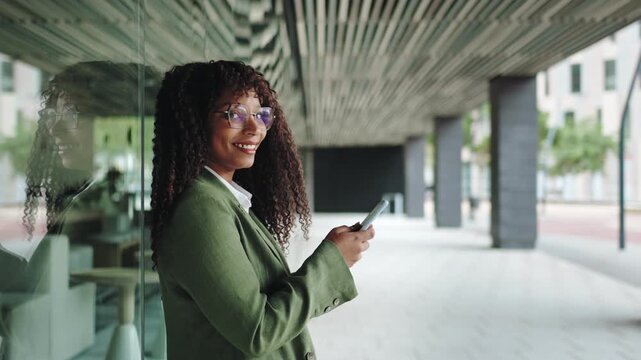 Elegant professional business woman wearing suit using mobile phone app outside office 