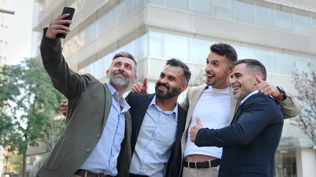 Group of cheerful businessmen taking a selfie with a mobile phone app celebrating deal partnership