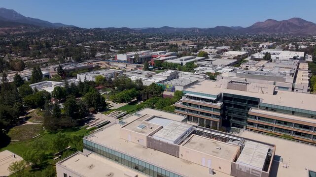 Amgen corporate offices in the foreground against the backdrop of Thousand Oaks, California and the mountains overlooking the Conejo Valley - aerial flyover