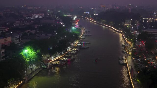 Glowing city lights illuminate the Martapura River in Banjarmasin, Indonesia
