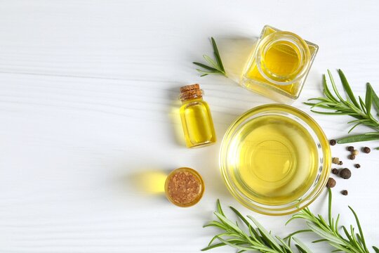 Top view of rosemary oil with green rosemary sprig, aromatic oil for cooking. Homemade rosemary oil, natural cooking seasoning. Organic spiced oil. Herbs. Aromatherapy. Healthy cooking.