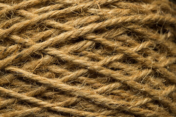 Obraz premium Macro closeup of natural brown jute twine rope texture,A detailed close-up photograph showcasing the coarse, fibrous texture and twisted pattern of natural brown jute rope wound tightly together.