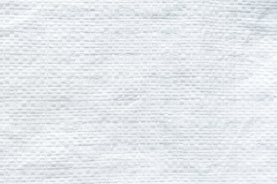 White woven plastic sack texture background,A detailed close-up macro view of white woven polypropylene plastic sack material, creating a clean geometric grid pattern suitable for industrial,