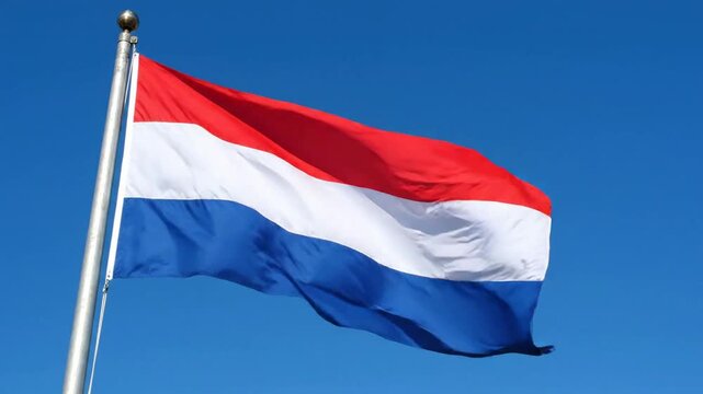 Netherlands flag waving proudly in the wind against a clear blue sky national symbol of the netherlands
