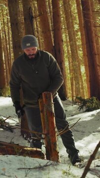 Lumberjack splitting wood with an axe in a snowy forest