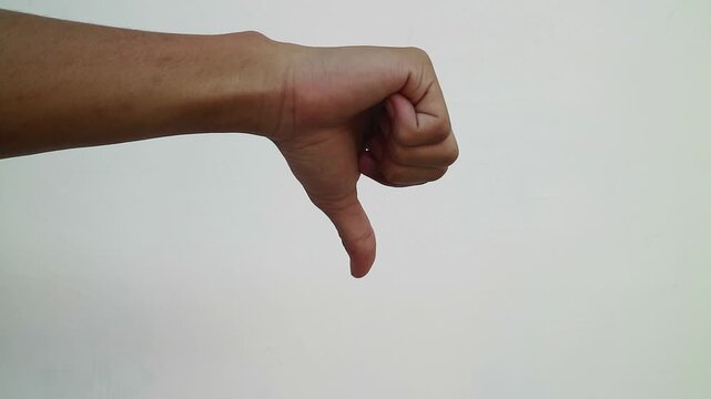 A close up of a hand showing a thumbs down gesture against a plain white background.