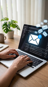 Hands typing on laptop showing email inbox with flying envelopes, symbolizing communication and connectivity in a modern workspace.