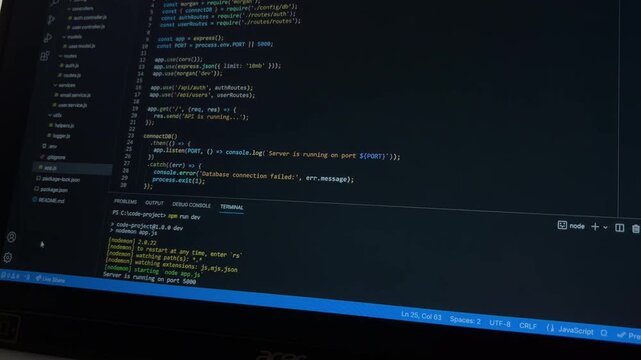 Developer writing javascript code on a laptop screen showing a running server and debugging process on the terminal, representing programming and software development