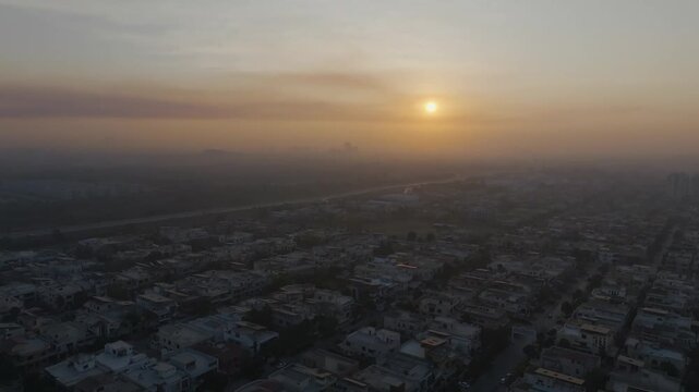 Hazy sunrise aerial view over Sector E-11 residential community and Margalla Road in Islamabad