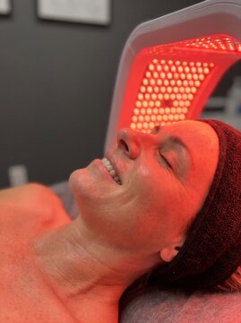Woman taking photobiomodulation infrared LED facial therapy. Hardware cosmetology, dermatology and skincare treatment concept. Close-up portrait for commercial poster