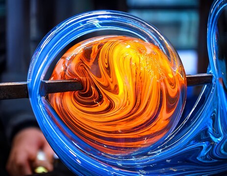 fiery molten glass in vibrant orange and blue hues swirling together showcasing the intricate art of glass blowing during production