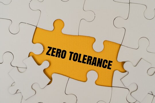 "ZERO TOLERANCE" text on puzzle pieces. Symbolizing corporate policy, strict rules, law, and compliance concept