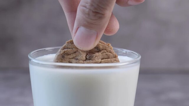 Hand Cookie Dipping into Glass of Milk Close-Up - Sweet Snack Dessert Food Video